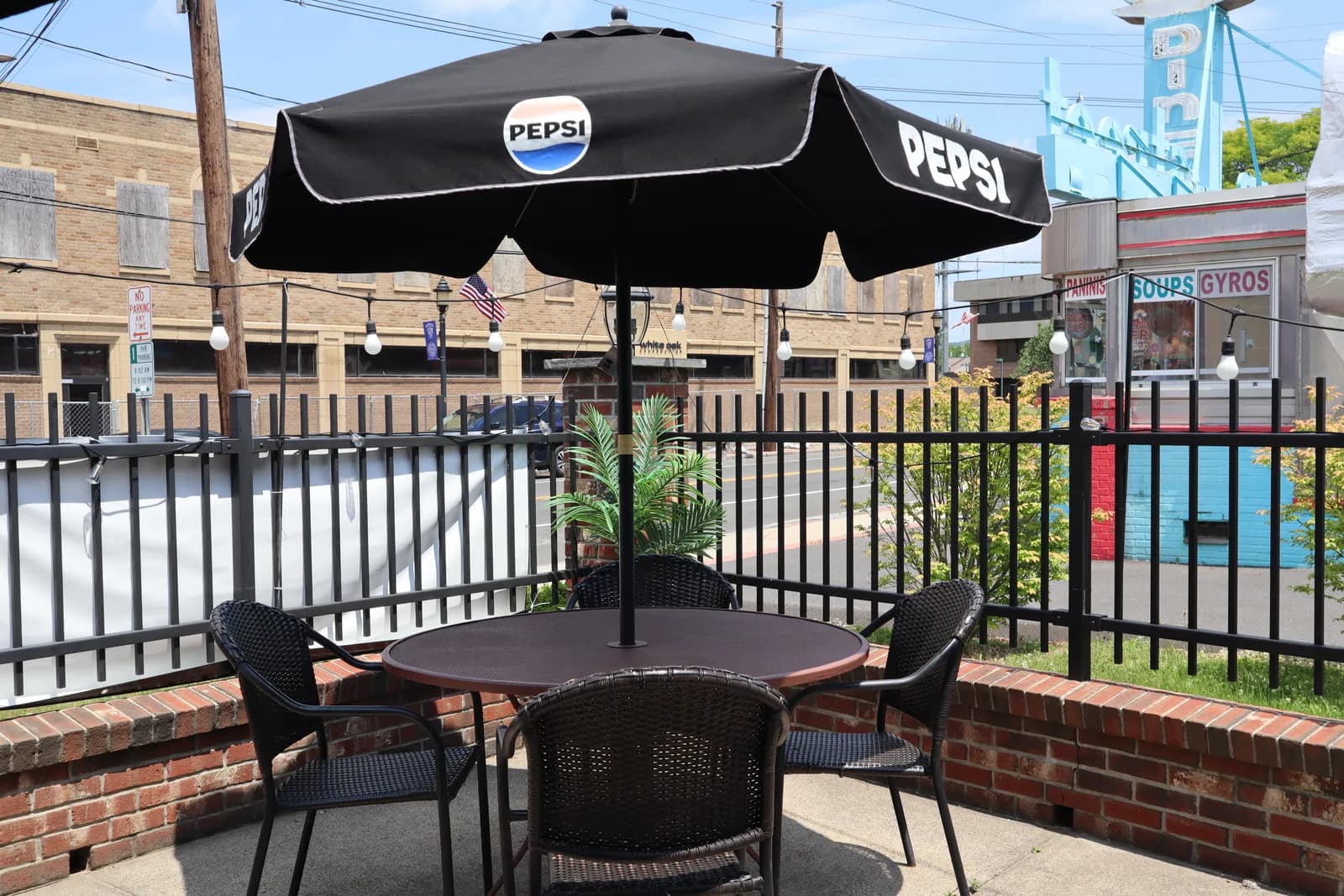 Outdoor patio seating with umbrella-shaded tables at Royal Xperience De'Maria